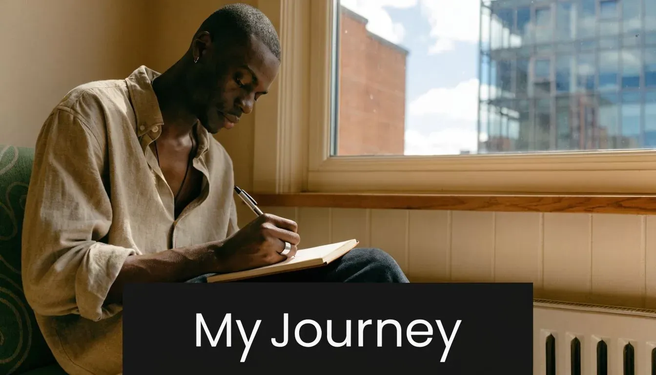A young Black man sitting by a sunny window writing in a journal with a pen.